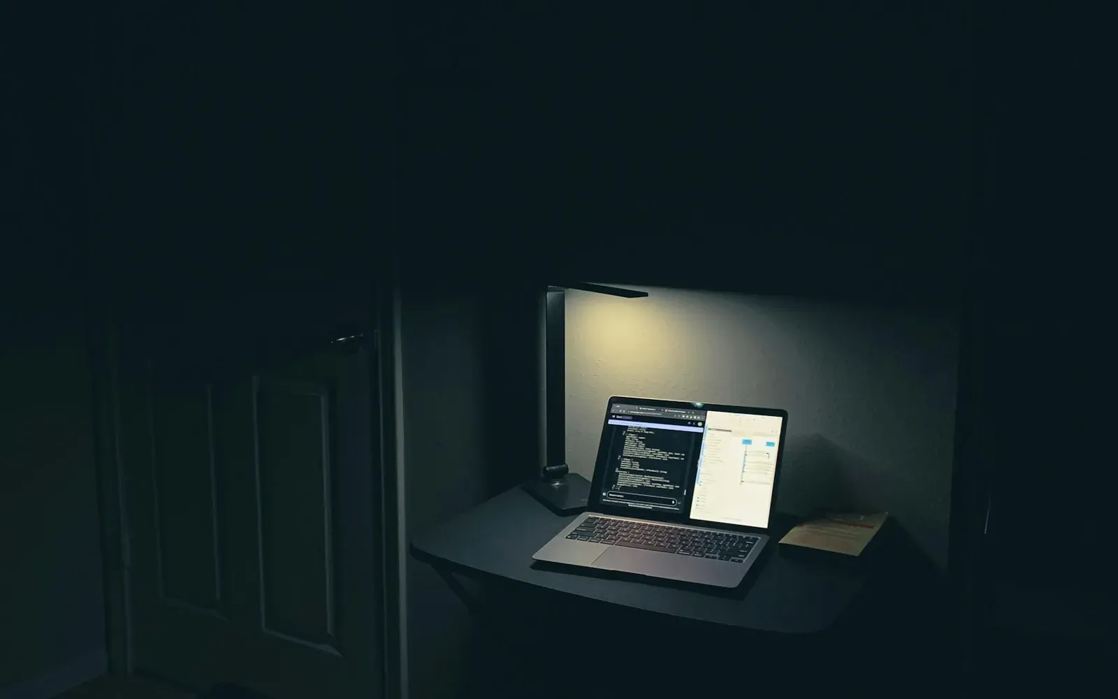 Aufgeklappter Laptop auf einem Tisch in einem dunklen Raum – Webcam Privatsphäre beim Camsex