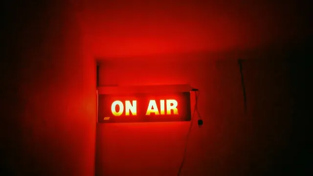 Rot leuchtendes On-Air-Schild an einer dunklen Wand – Chaturbate, Stripchat und BongaCams im Vergleich